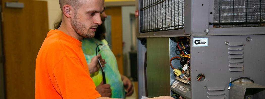 HVAC student works on an air conditioning unit