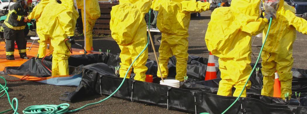 A group of first responders wearing yellow hazmat suits