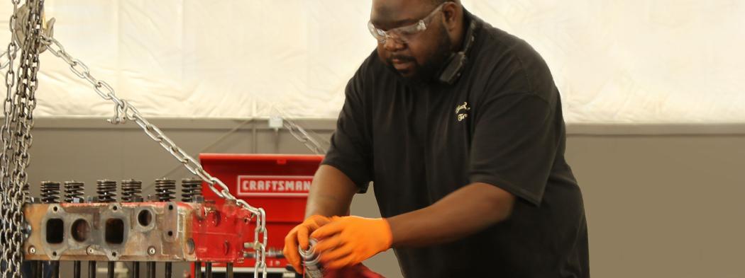 Male student works on red engine in Diesel Engines program