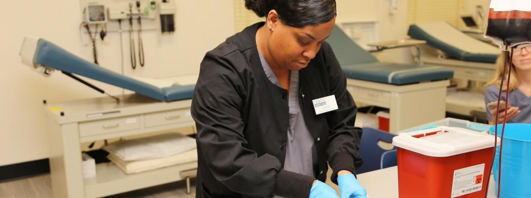 Medical Assisting student practices inserting needle on faux arm