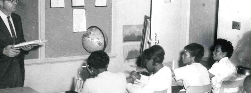 Male instructor speaks to class in 1970s