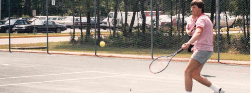 Male student playing tennis in 1980s