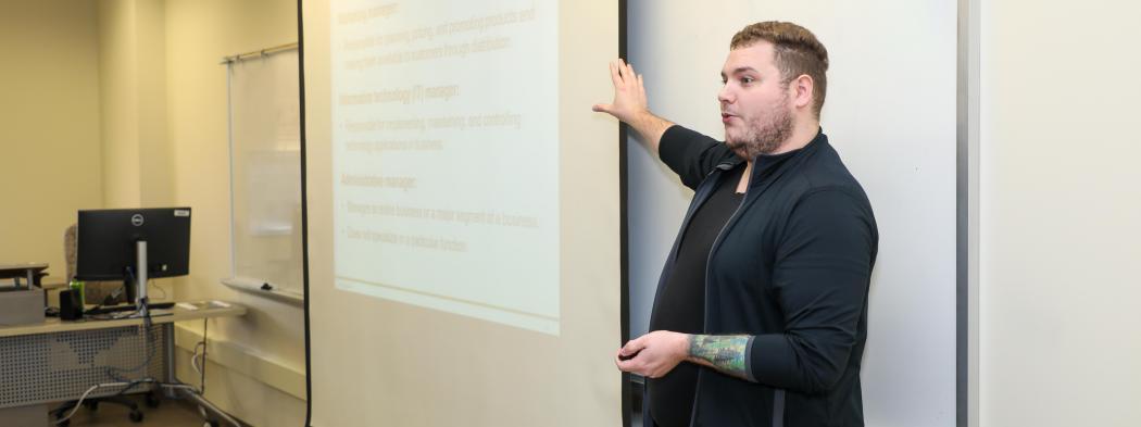 Instructor presenting a lesson on types of management in a classroom.