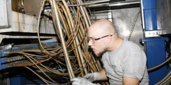 Aaron Davenport, maintenance technician for Schlaadt of New Bern, inspects hoses on a machine that creates Styrofoam molds that are used to ship Bosch appliances. Davenport was hired at Schlaadt after graduating from Craven Community College in May with an Associate in Applied Science degree in Electronics Engineering Technology.