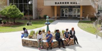 students sitting around outside fountain