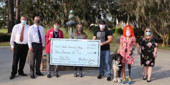 College officials and student Paige Winter pose with giant check