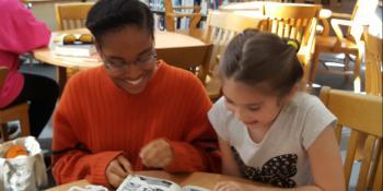 Craven Early College student reads a book to an elementary student