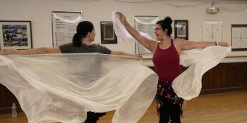 Two women have fun in a belly dancing class