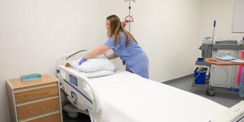 Meghan Margarum practices environmental services and housekeeping tasks in a hospital room.