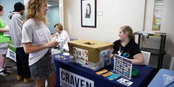 Student at a resource table learning about college options