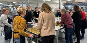 Students in the Community Enrichment Program's Biscotti Baking class gather around kitchen tables to admire freshly baked biscotti.