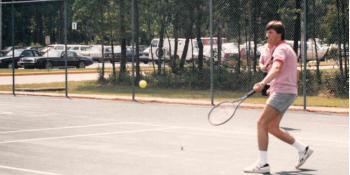 Male student playing tennis in 1980s