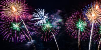 Dark night sky illuminated by several colorful fireworks.