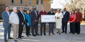 Members of the Whittenburg Foundation and Craven Community College Foundation, Health Sciences staff, and two male students post with a large check for $10,000