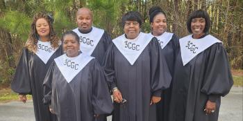 Five females and one male gospel choir member in black robes with white bibs