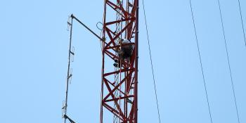 climber stands on antenna