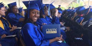 Craven CC employee Rodnekia Stewart shows off her diploma holder during her commencement ceremony