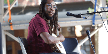 Musician Hubby Jenkins plays a banjo on stage with a microphone