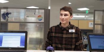 Alum and Craven employee Matt Bircher helps a student at the admissions front desk
