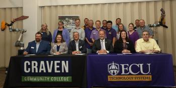People sitting at a table with tablecloths for Craven and ECU